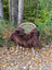 A cozy thick dark rusty brown wool icelandic sheepskin throw draped over a woven wicker chair with metal legs
