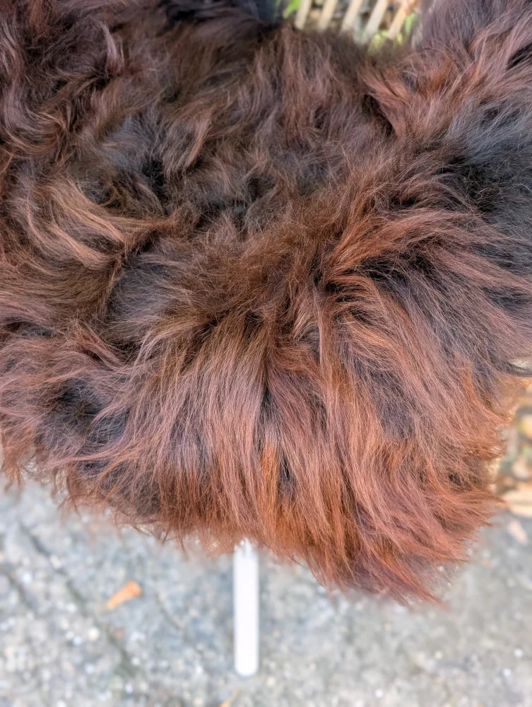 A plush curly brown and black wool icelandic sheepskin coat with soft dense texture measuring 49 by 31 inches