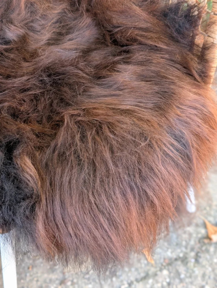 A plush shaggy brown wool icelandic sheepskin blanket in natural dark rusty shades 49 x 31 inches