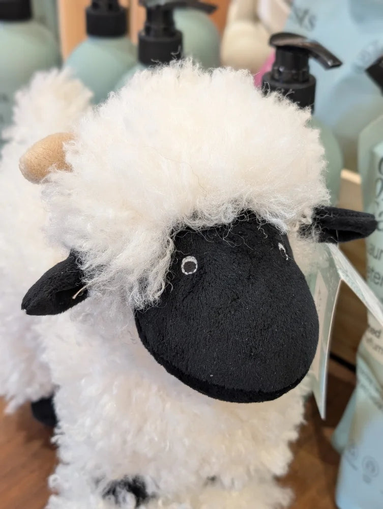 A plush nana huchy valentina the valais sheep toy with fluffy white wool, black face, and tan horns