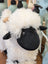 A plush nana huchy valentina the valais sheep toy with fluffy white wool, black face, and tan horns