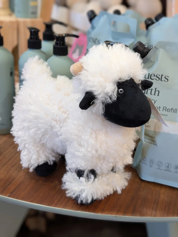 A plush white valais sheep with black face and legs featuring soft fluffy texture from nana huchy collection