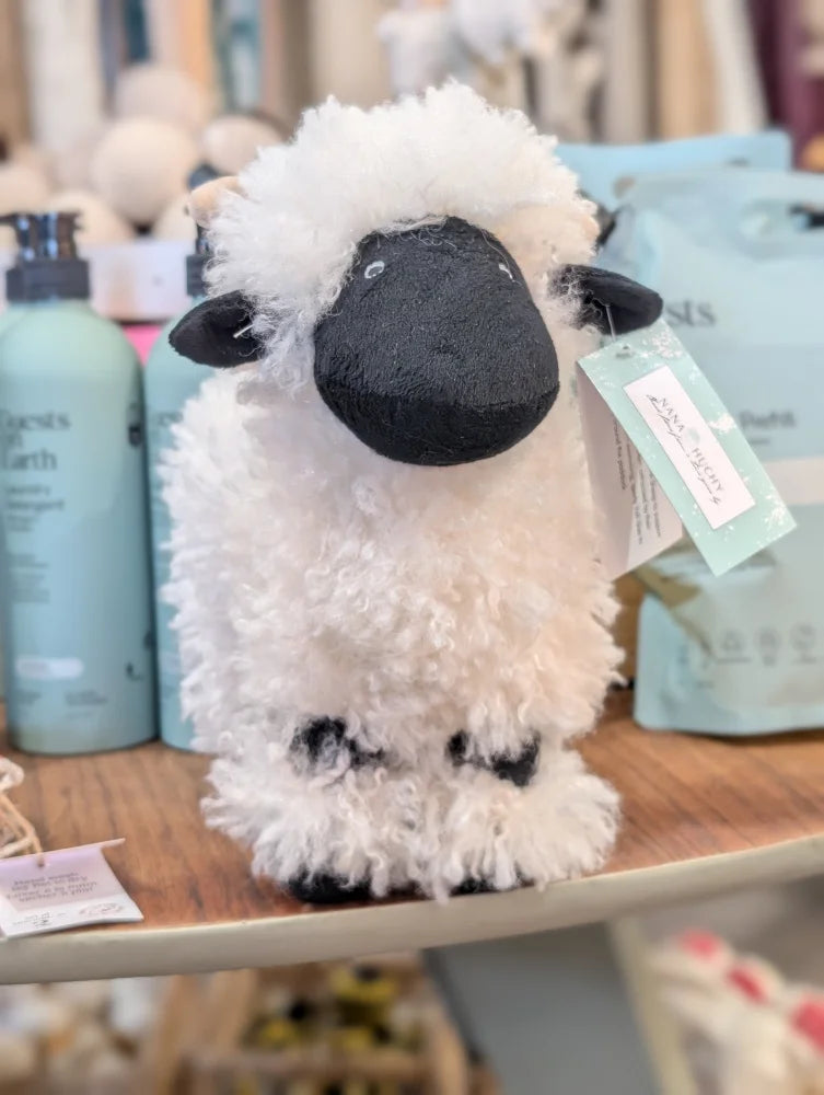 A plush nana huchy valais sheep with black face fluffy white woolly fur and black hooves soft stuffed texture