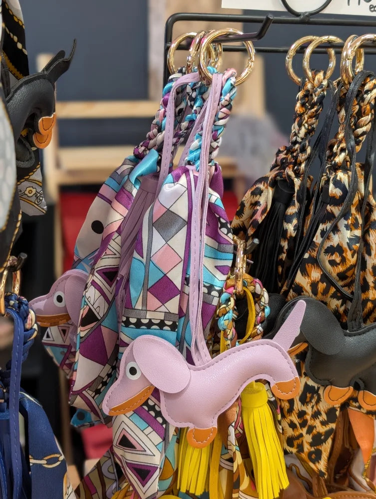 Violet dachshund bag charm in pink leather with orange accents, yellow tassels by Angus Oliver