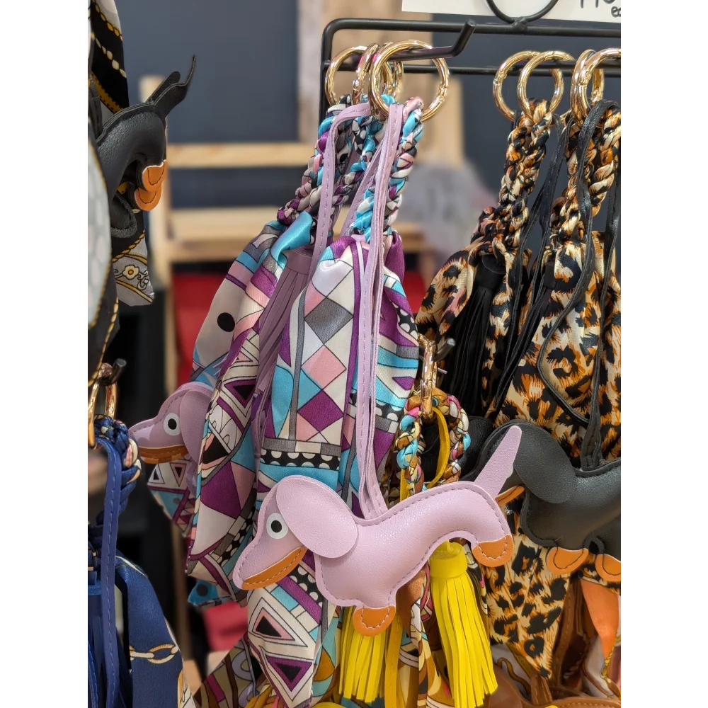 Violet dachshund bag charm in pink leather with orange accents, yellow tassels by Angus Oliver