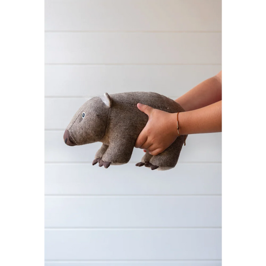 Wally the wombat is a soft brown woolen plush toy with textured fabric and embroidered eyes, perfect for cozy decor like cowhide rugs