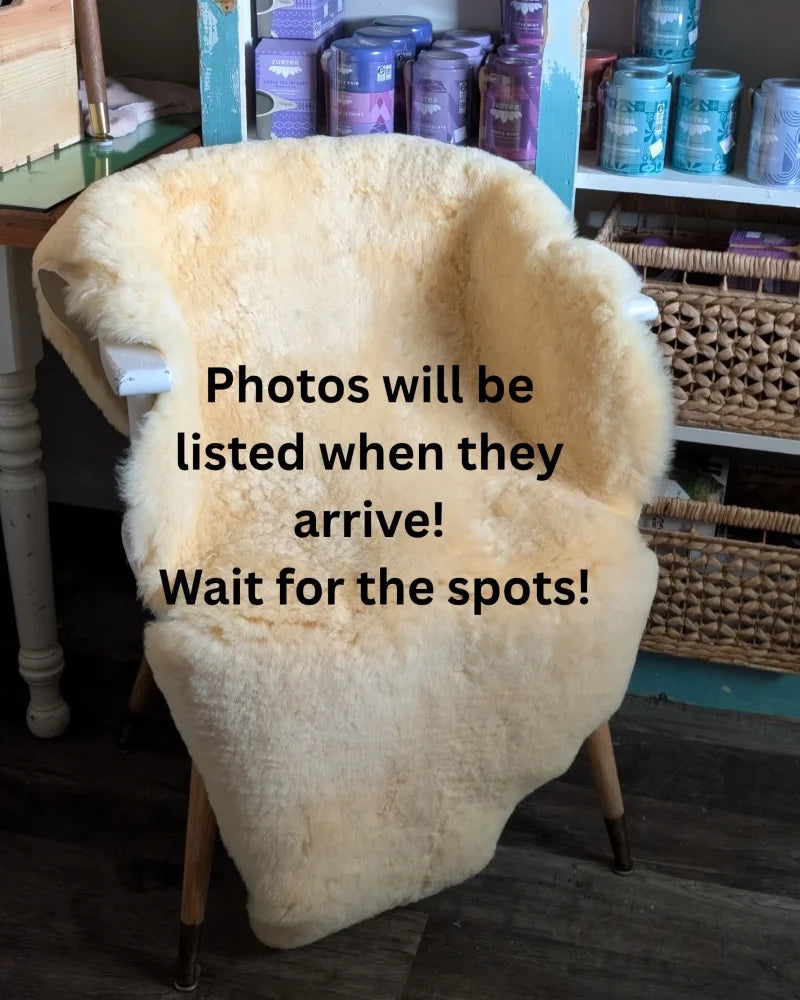Cream-colored washable medical sheepskin chair cover draped over wooden frame large angus oliver style