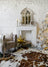 White gothic arched mirror with a wooden frame resting on a white fireplace mantel