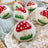 White felted wool dryer balls hand-painted with red mushroom and green grass by angus oliver for dryer sheets use