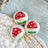 Three fluffy white wool dryer balls embroidered with red mushroom caps and green grass by angus oliver