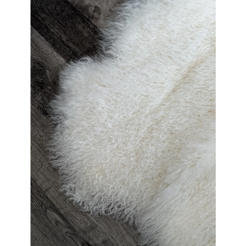 Gorgeous natural white Mongolian sheepskin rug on dark wood floor
