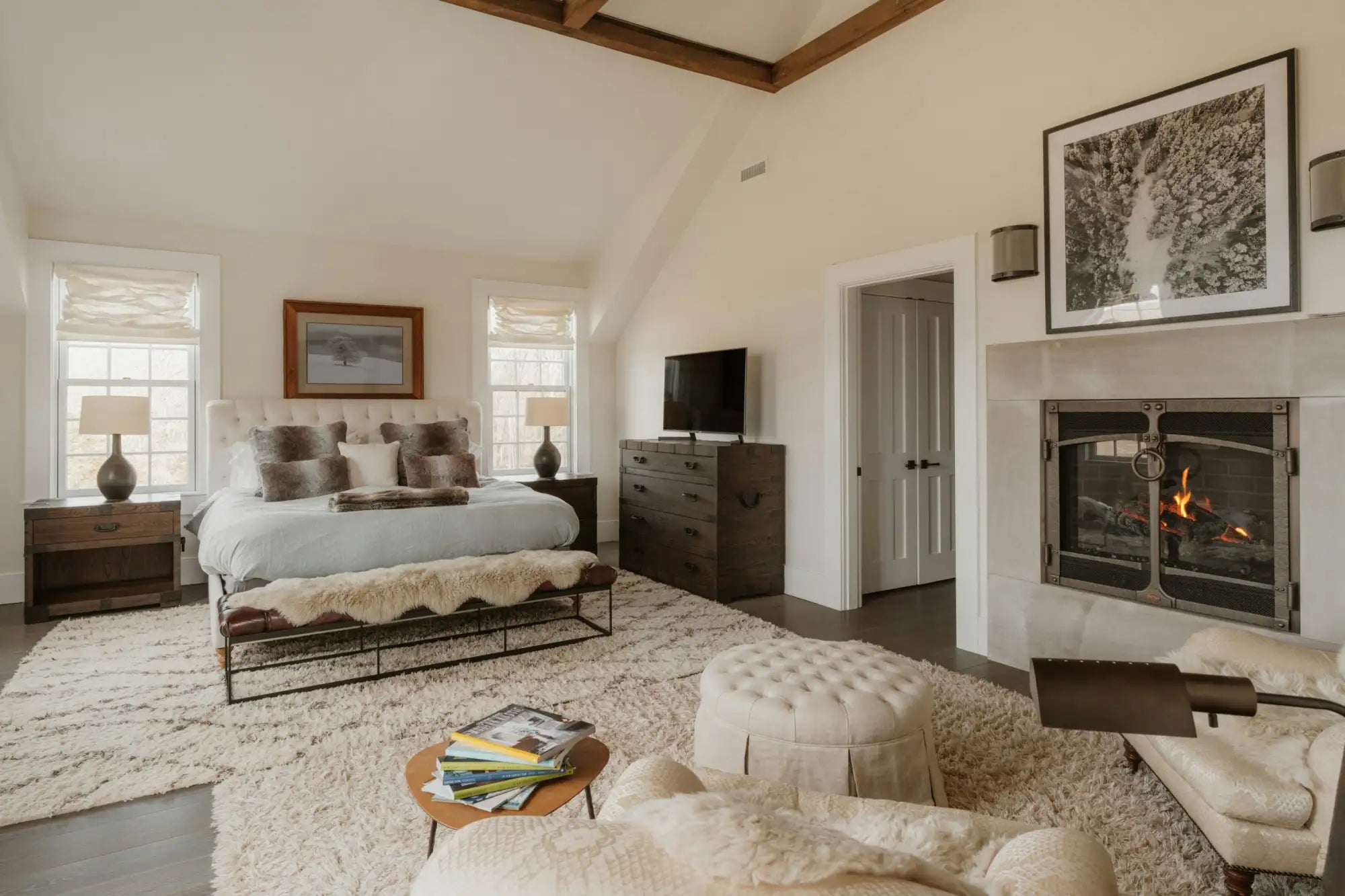 White tufted ottoman with a soft, upholstered surface and wooden legs.