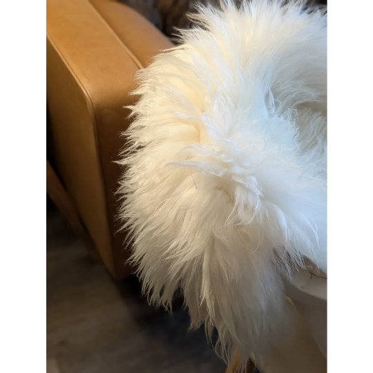 A plush white icelandic sheepskin rug with long soft strands and fluffy texture in 48 x 31 inches size