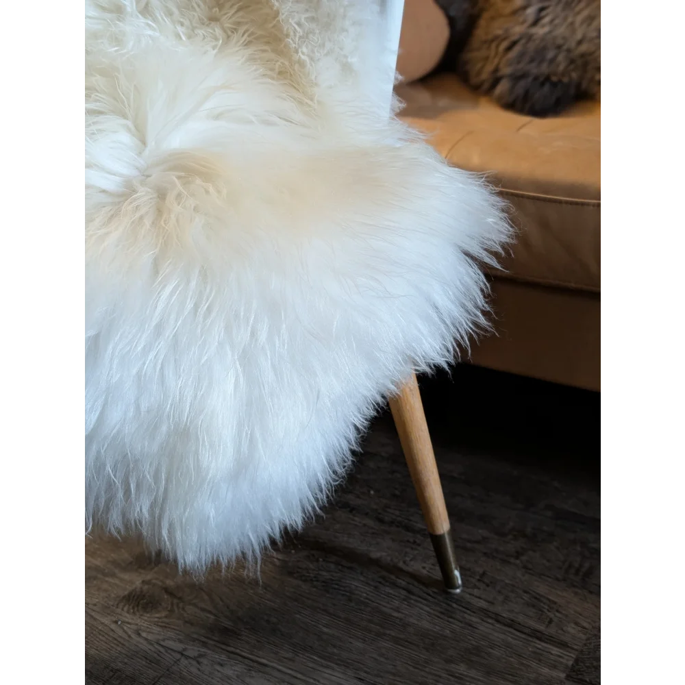 White soft icelandic sheepskin rug draped on modern chair with wooden legs 48x31 inches grade a sheepskin throw