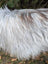 A long shaggy icelandic sheepskin coat in natural grey with white and subtle dark streaks featuring long wool