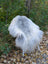 A fluffy white and gray massive icelandic sheepskin chair with slender white legs made of wool icelandic sheepskins