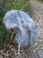 A plush light gray wool icelandic faux fur throw draped over a white metal chair with woven wicker accents