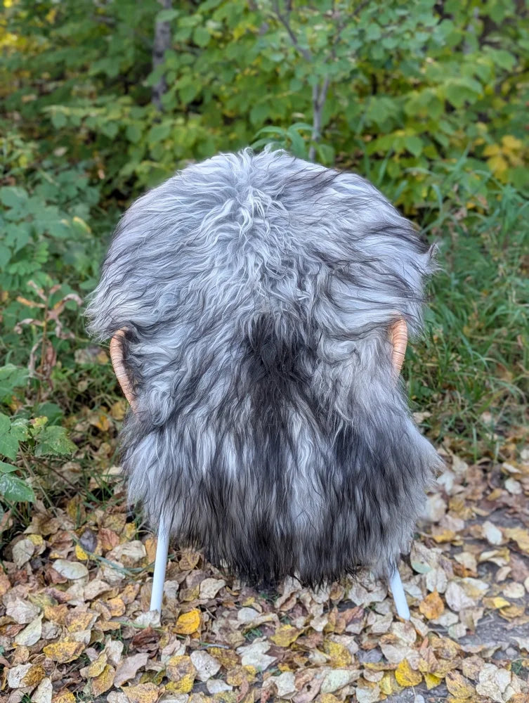 Gray and black faux fur chair with wooden ears and white legs featuring massive icelandic sheepskin material