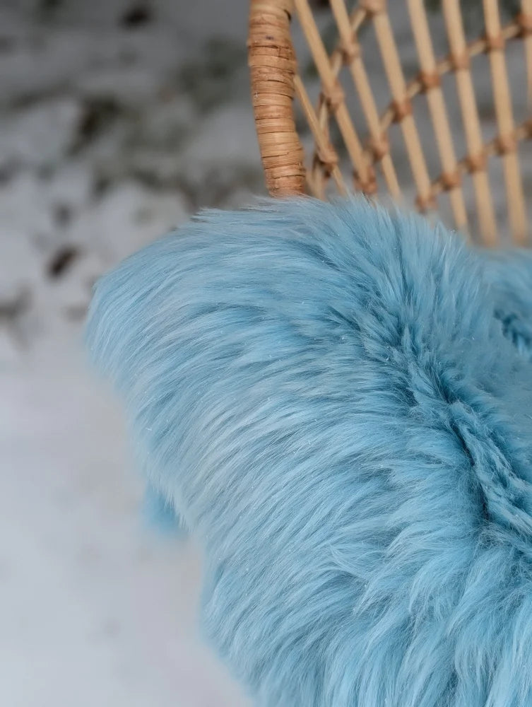 A soft light blue faux fur throw blanket with plush texture from winter blue green merino sheepskin collection