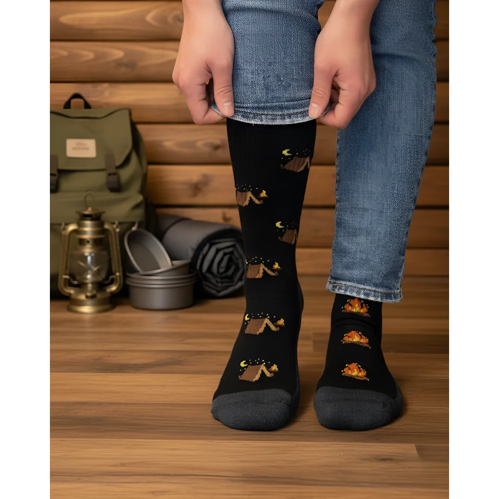 Black knee-high merino wool socks with playful camping tents and campfires perfect for cozy outdoor vibes by angus oliver