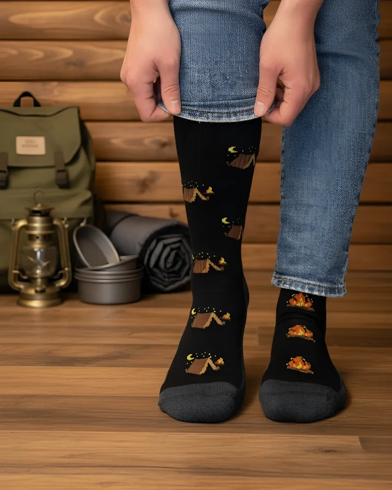 Black knee-high merino wool socks with playful camping tents and campfires perfect for cozy outdoor vibes by angus oliver