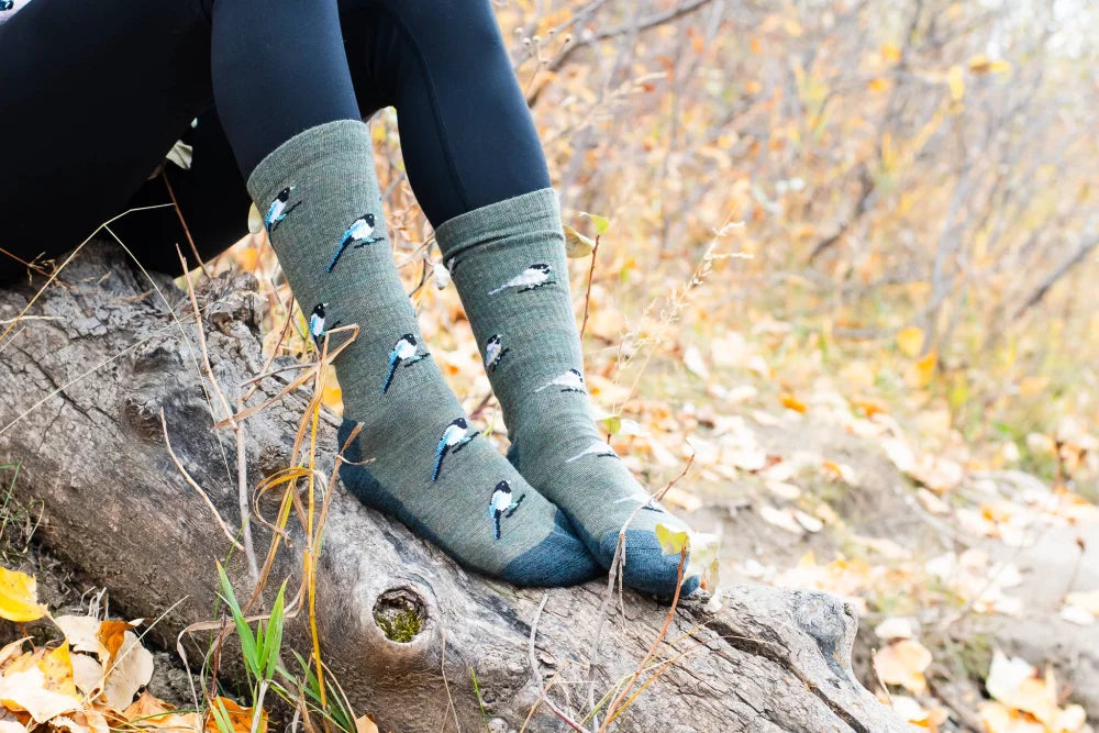 Olive green merino wool socks with black and white bird patterns and ribbed cuff perfect for hiking and outdoor use