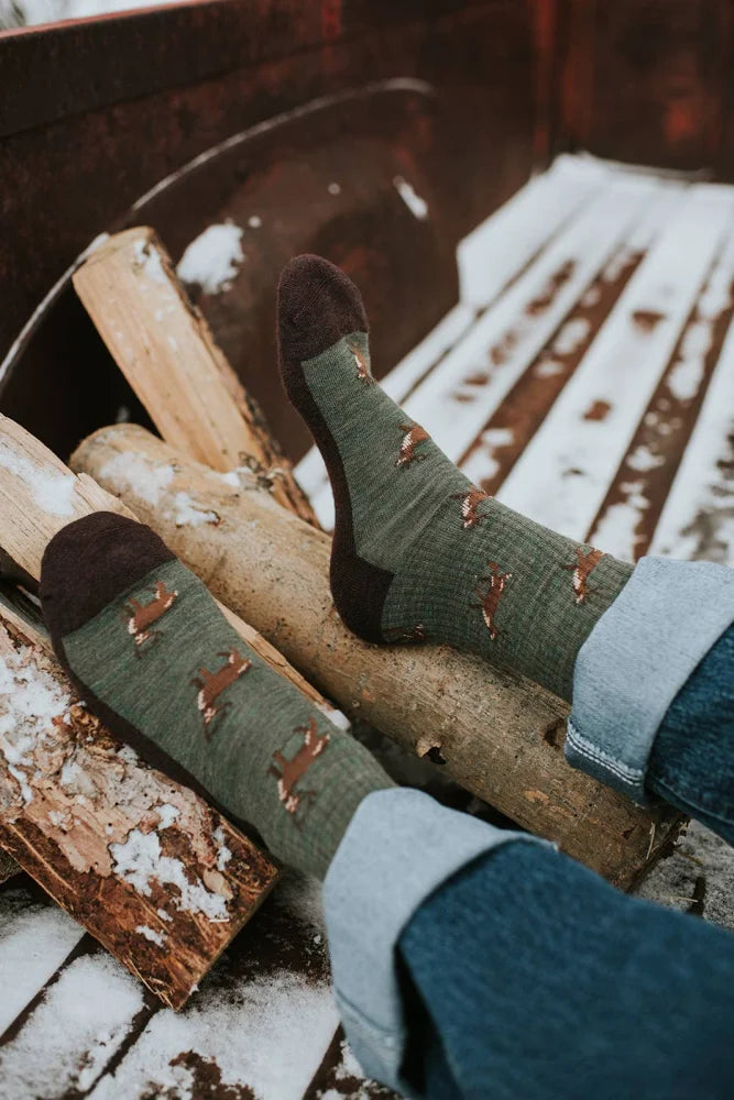 Women’s olive green merino wool socks with brown fox prints and dark brown toes worn with rolled-up jeans