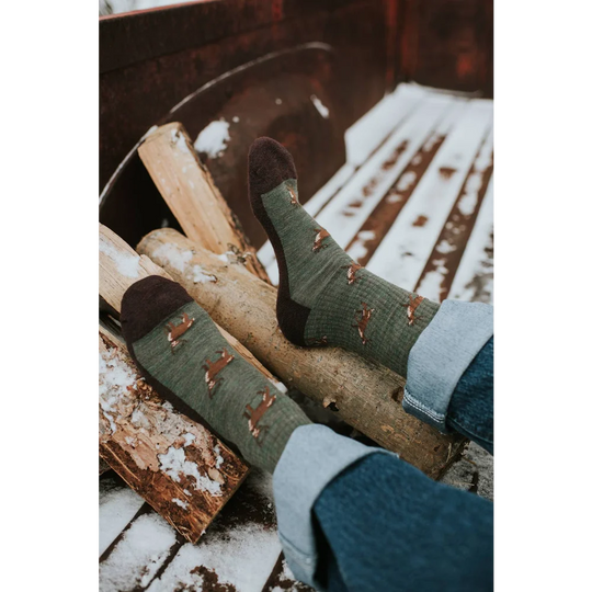Women’s olive green merino wool socks with brown fox prints and dark brown toes worn with rolled-up jeans