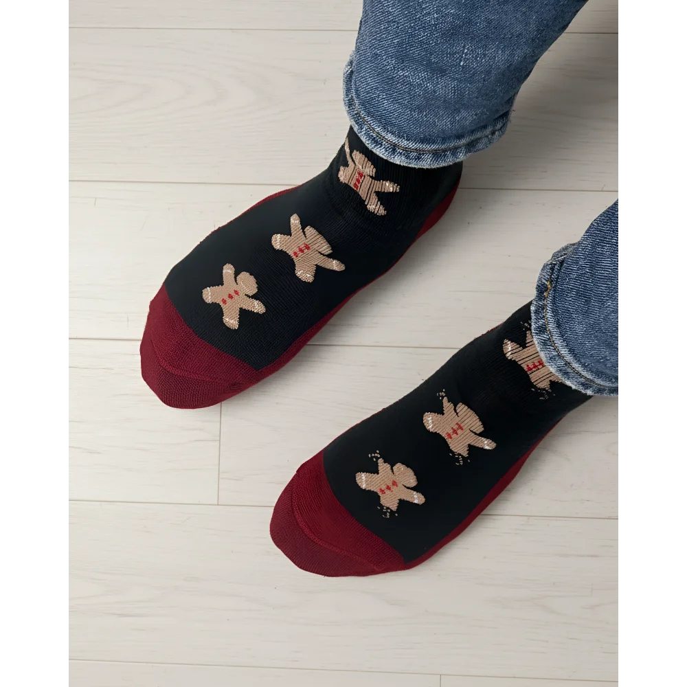 Women’s gingerbread bite merino wool socks in black and red with beige gingerbread men by angus oliver