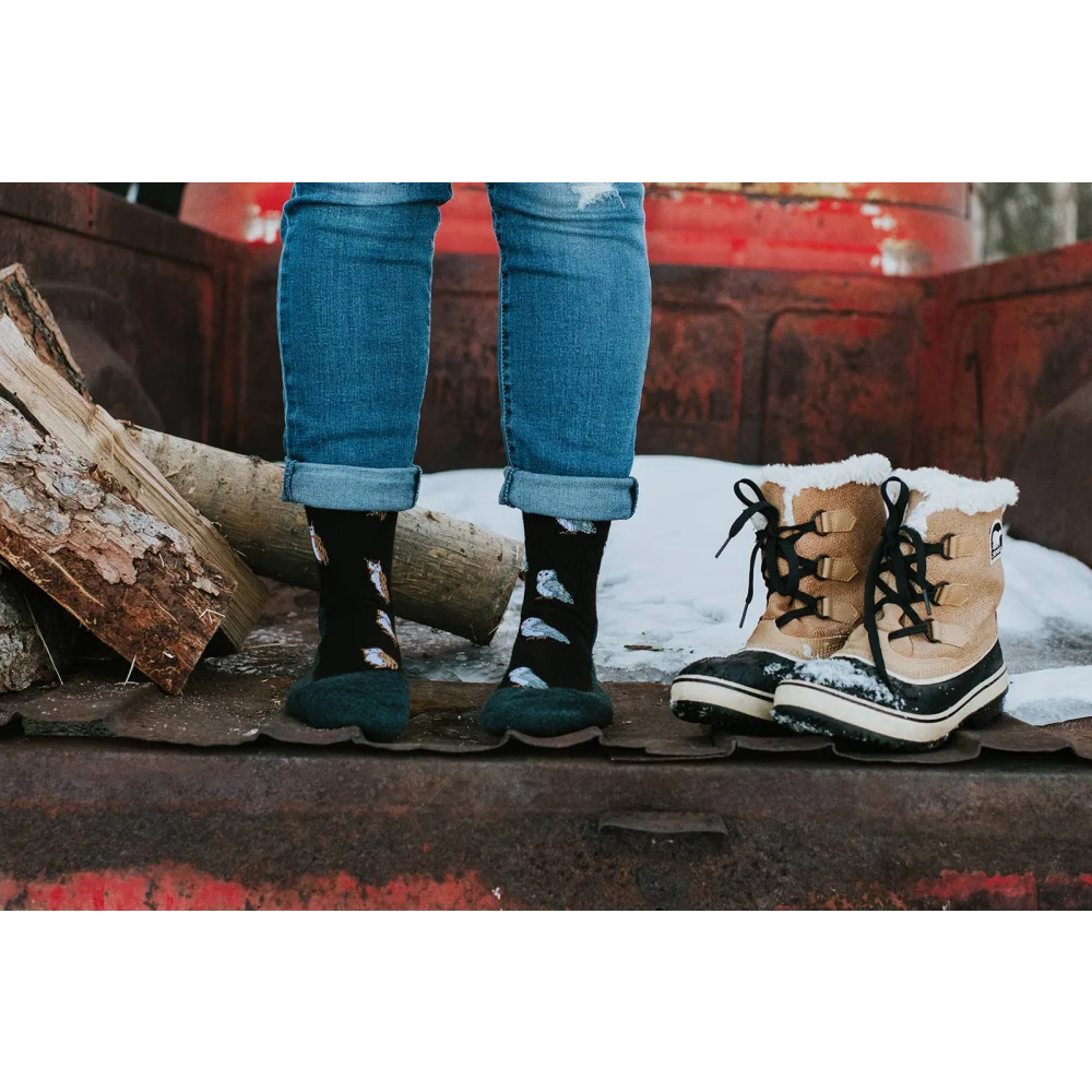 Tan and black sorel winter boots with white fur lining paired with womens owl merino wool socks for soft comfort by angus oliver