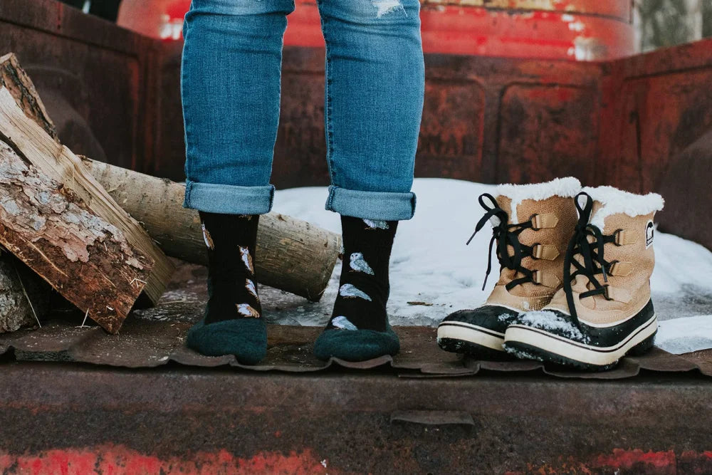 Tan and black sorel winter boots with white fur lining paired with womens owl merino wool socks for soft comfort by angus oliver