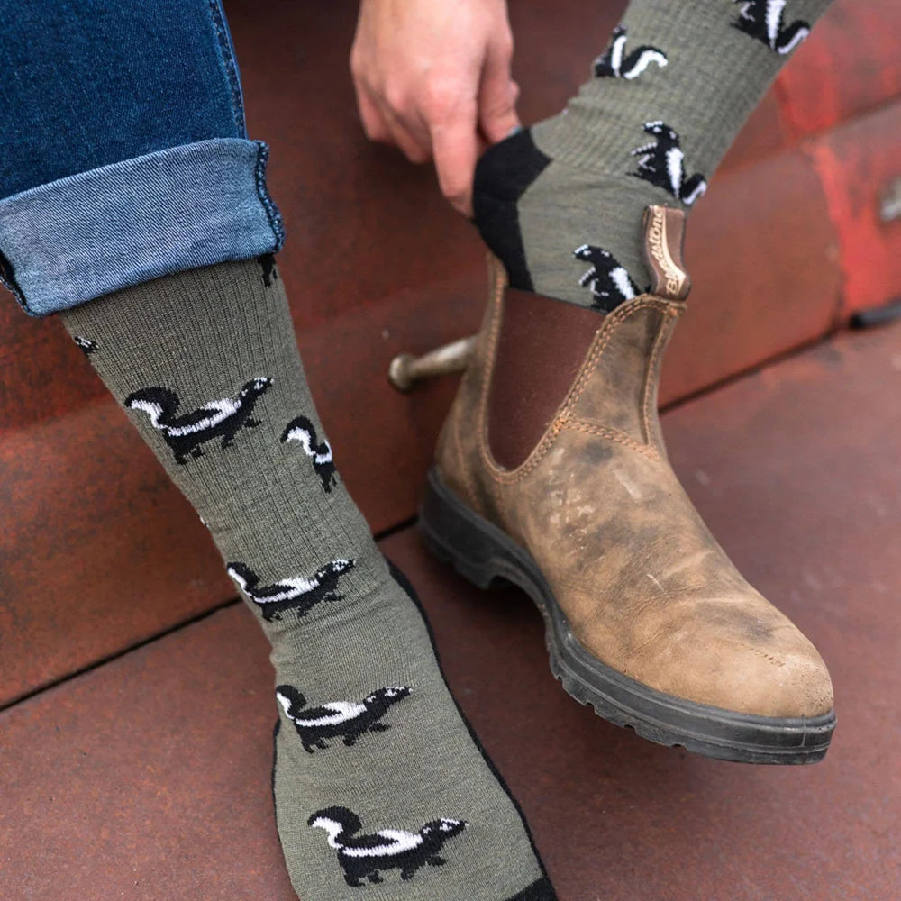 Olive green merino wool socks for women with black and white skunk pattern perfect as a mismatched gift idea