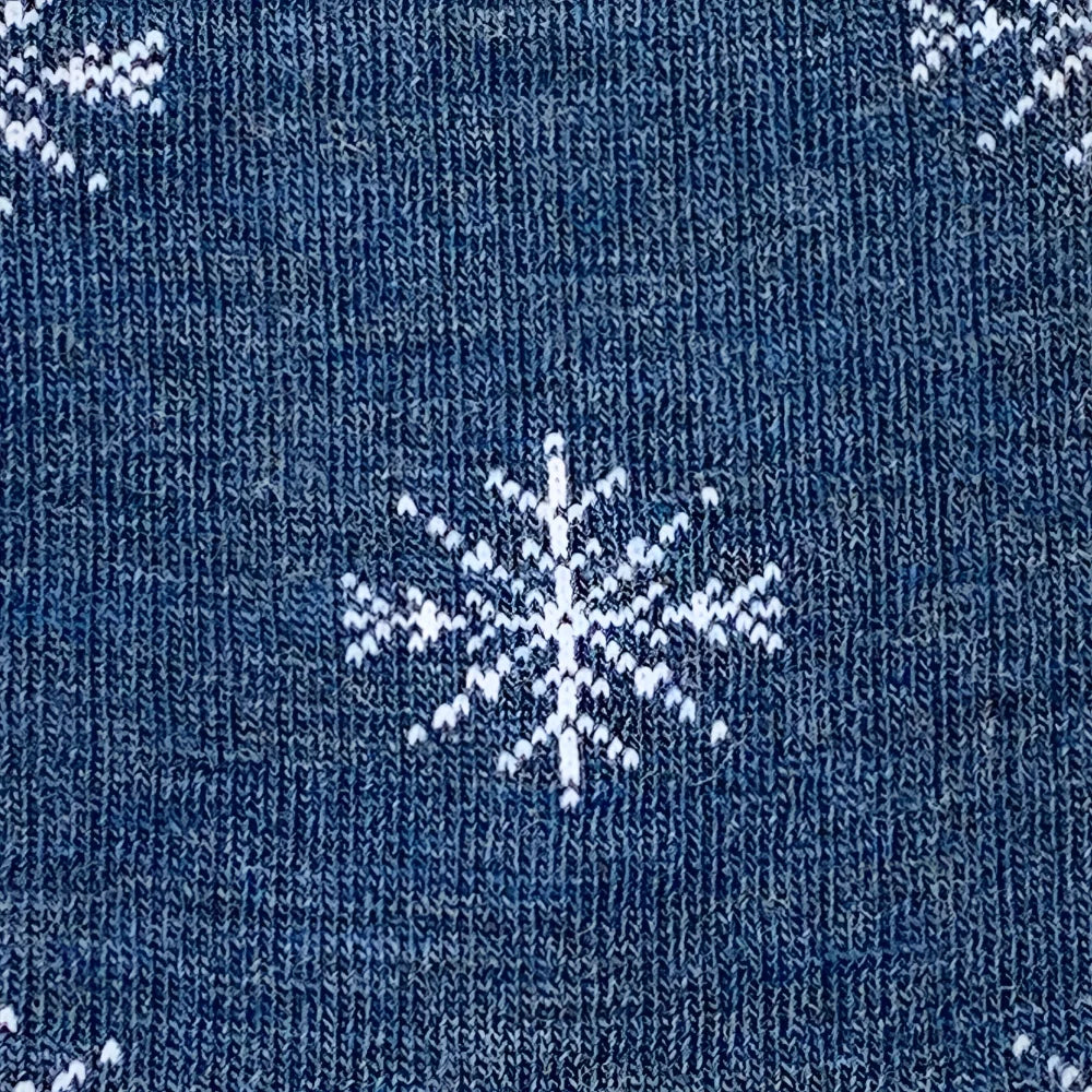 Blue knitted sweater with white snowflake patterns paired with cozy merino wool socks for winter comfort by angus oliver
