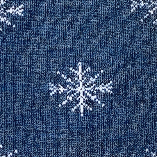 Blue knitted sweater with white snowflake patterns paired with cozy merino wool socks for winter comfort by angus oliver