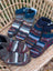 Three pairs of hand-knitted swool stripe wool booties with cozy multicolored stripes and ribbed cuffs for adults