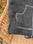 A dark gray knitted drawstring bag with lighter gray stitched pocket outline and black closure perfect for jasper vest use