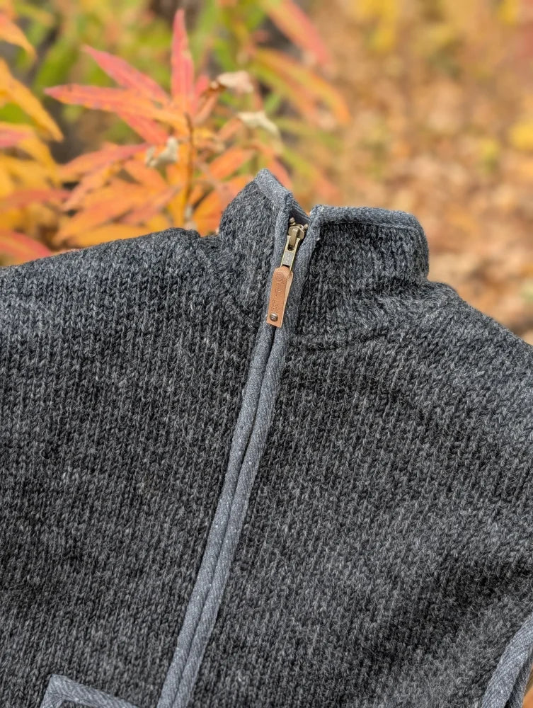 Dark gray woolen jasper vest with soft fleece lining and full-length zipper featuring leather pull tab