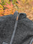 Dark gray woolen jasper vest with soft fleece lining and full-length zipper featuring leather pull tab