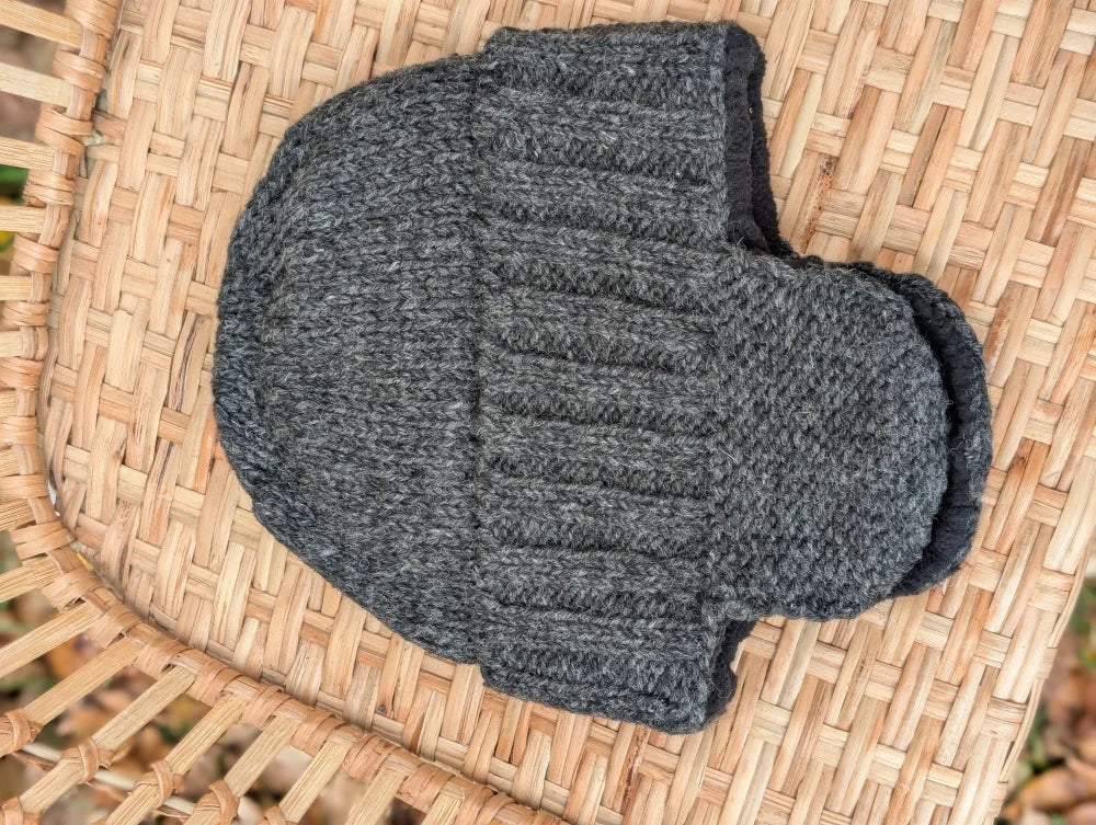 A cozy dark gray woolen solo ear flap hat with ribbed texture and folded cuff for warm winter wear