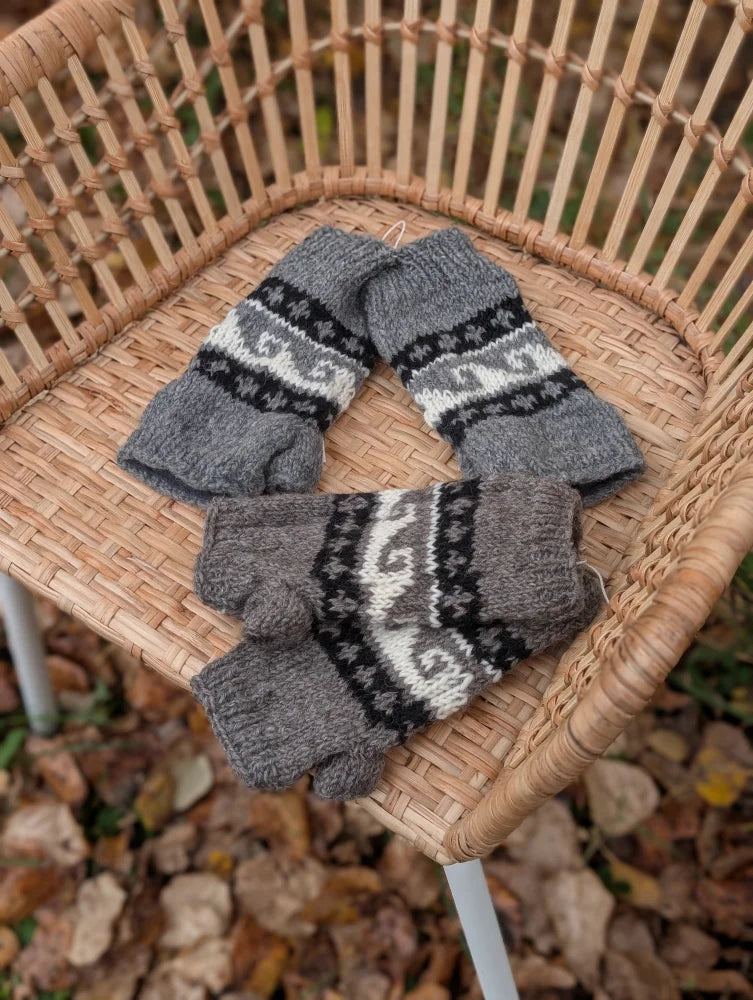 Gray knit fingerless hand warmers with black and white nordic patterns made from fair trade zealand wool