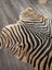A plush angus oliver large cowhide rug with bold black and tan zebra print and unique characteristics