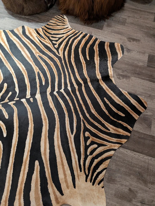 Gorgeous zebra printed large cowhide rug by angus oliver with black and tan faux fur and a natural irregular edge