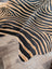 Gorgeous zebra printed cowhide rug with black and tan zebra stripes and unique characteristics by angus oliver