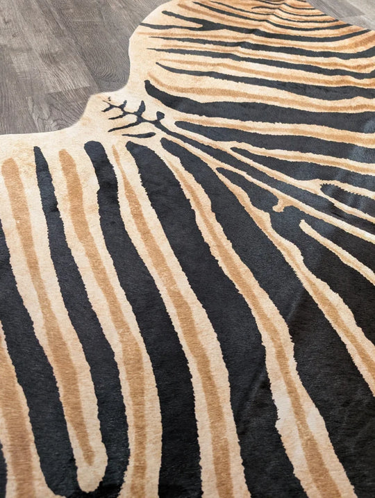 A gorgeous zebra printed cowhide rug by angus oliver with bold black and tan stripes and unique characteristics