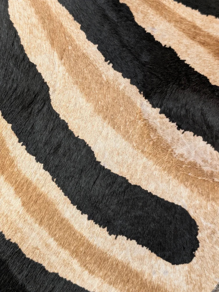 Plush faux leather large cowhide rug with bold black and tan zebra stripes showing unique characteristics by angus oliver