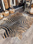 Gorgeous zebra printed large cowhide rug with bold black and tan stripes showcasing unique characteristics by angus oliver