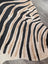 Large cowhide zebra printed faux fur rug in black and beige with unique characteristics by angus oliver
