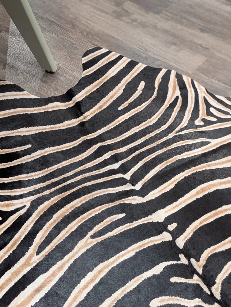 Large cowhide zebra printed faux fur rug in black and beige showcasing unique characteristics by angus oliver