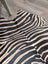 Large cowhide zebra printed faux fur rug in black and beige showcasing unique characteristics by angus oliver