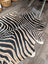Large cowhide zebra printed faux fur rug in black and beige with unique characteristics by angus oliver